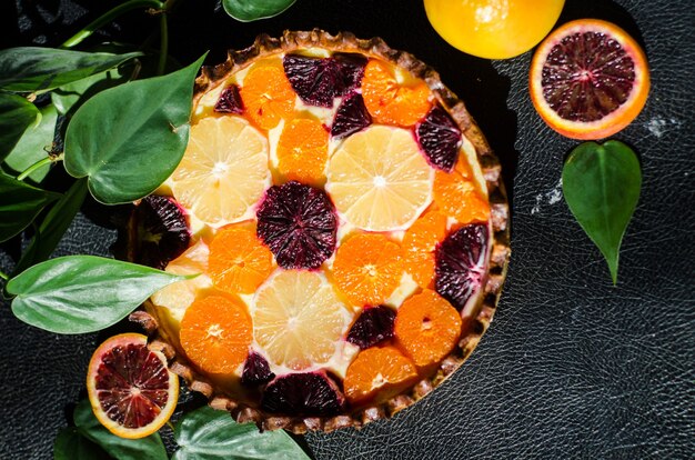 Disparo de alto ángulo de un delicioso pastel de naranja recién horneado sobre una superficie negra