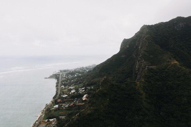 Disparo de alto ángulo de una montaña empinada en la orilla del mar con un cielo nublado