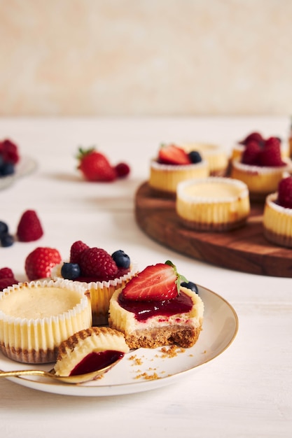 Disparo de alto ángulo de pastelitos de queso con mermelada de frutas y frutas en una placa de madera