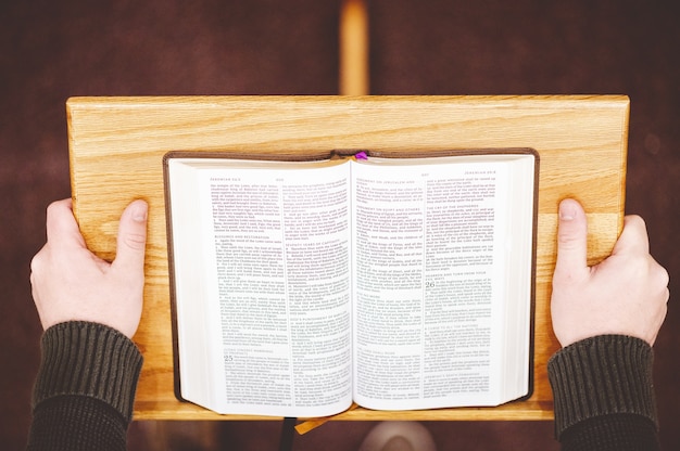 Foto gratuita disparo de alto ángulo de una persona que predica la santa biblia desde la tribuna en el altar de la iglesia