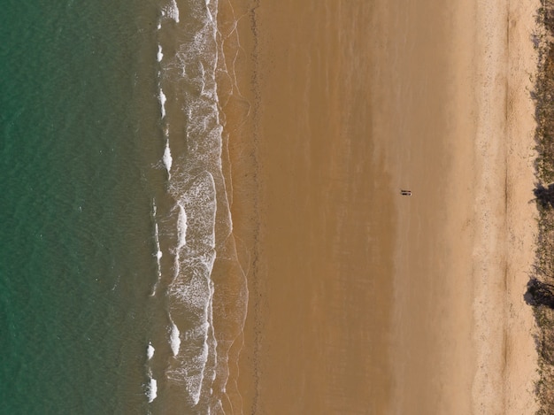 Disparo de alto ángulo de una playa con un pequeño pueblo en la orilla