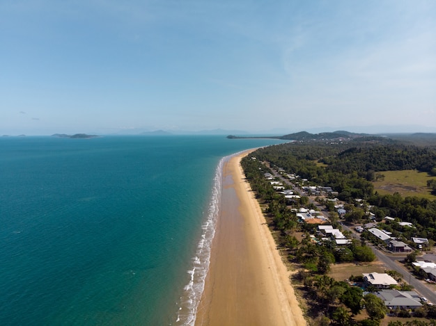 Disparo de alto ángulo de una playa con un pequeño pueblo en la orilla