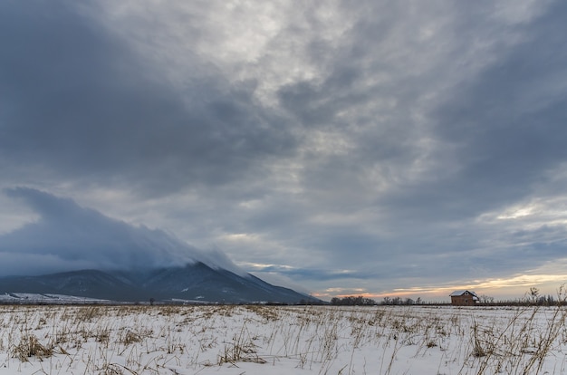 Disparo de alto ángulo de un valle cubierto de nieve bajo el oscuro cielo nublado