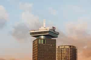 Foto gratuita disparo de ángulo bajo de un alto edificio histórico bajo un cielo nublado en amsterdam