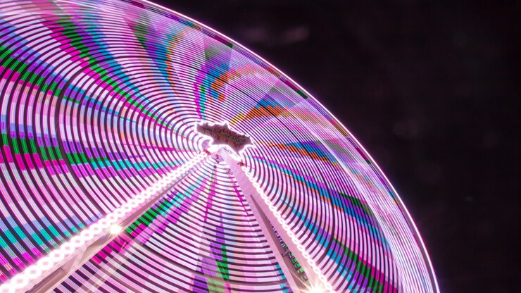 Foto gratuito disparo de ángulo bajo de un colorido parque de atracciones en la noche con un campo de juego