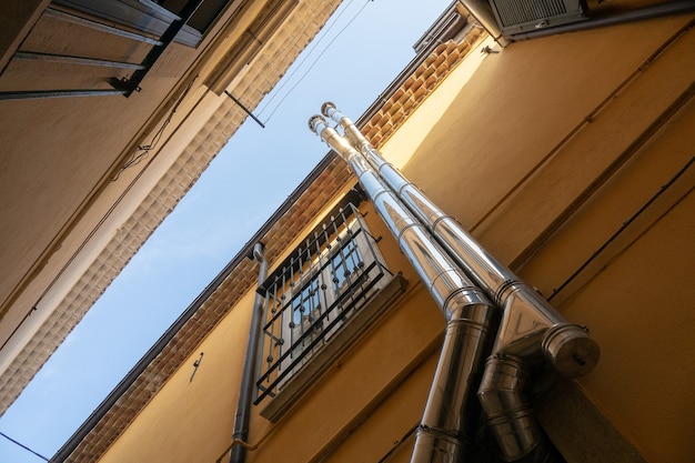 Disparo de ángulo bajo de dos tubos mientras suben por el edificio junto a una ventana