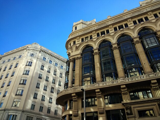 Disparo de ángulo bajo de edificios en España bajo un cielo azul claro