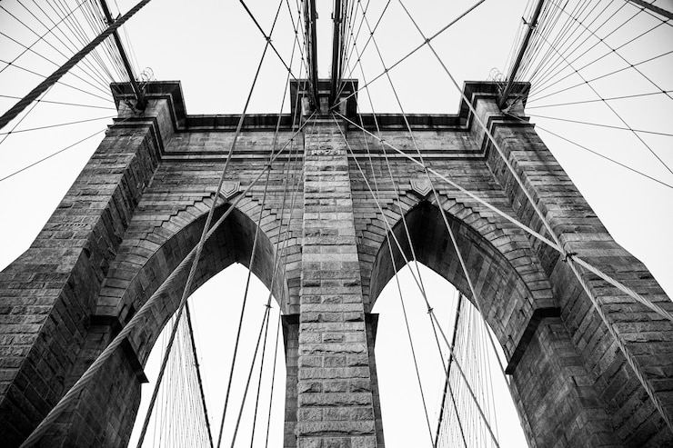 Foto gratuito disparo de ángulo bajo en escala de grises de un puente de brooklyn en la ciudad de nueva york