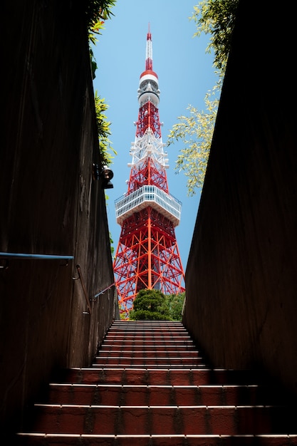 Disparo de ángulo bajo de la fascinante torre de Tokio con una escalera en primer plano