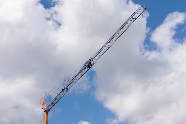 Disparo de ángulo bajo de una grúa de construcción bajo un cielo nublado