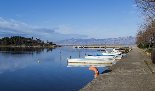 Disparo de ángulo de un lago con barcos atracados bajo un cielo azul