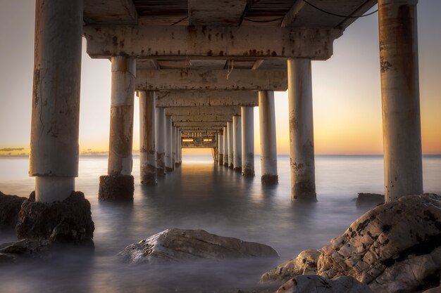 Disparo de ángulo bajo de un muelle en Marbella, España durante el amanecer