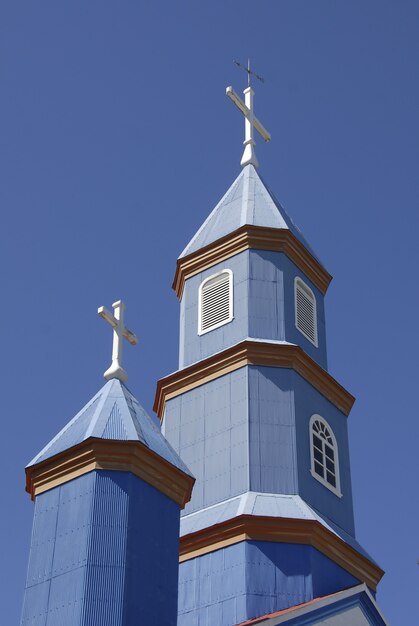 Disparo de ángulo bajo de una pequeña iglesia azul bajo un cielo azul y claro