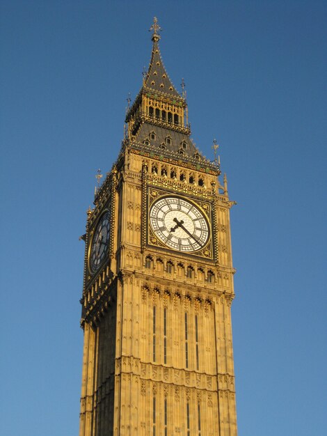 Disparo de ángulo bajo vertical del Big Ben de Londres bajo el cielo azul