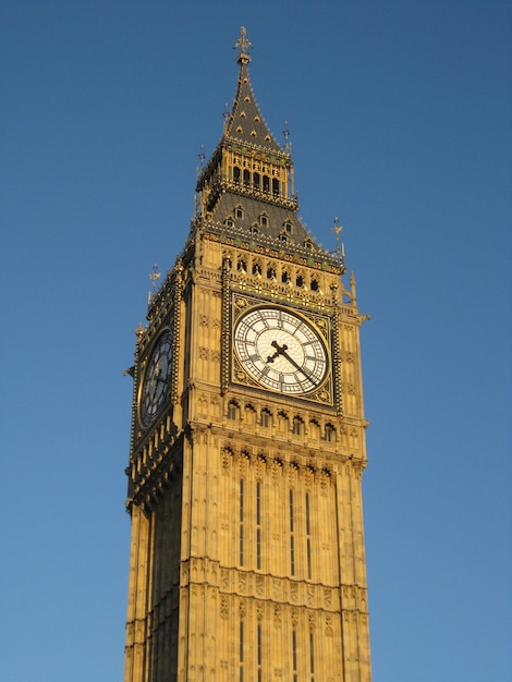 Disparo de ángulo bajo vertical del Big Ben de Londres bajo el cielo azul