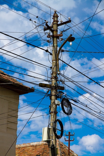 Disparo de ángulo bajo vertical de una gran cantidad de cables eléctricos bajo un cielo nublado