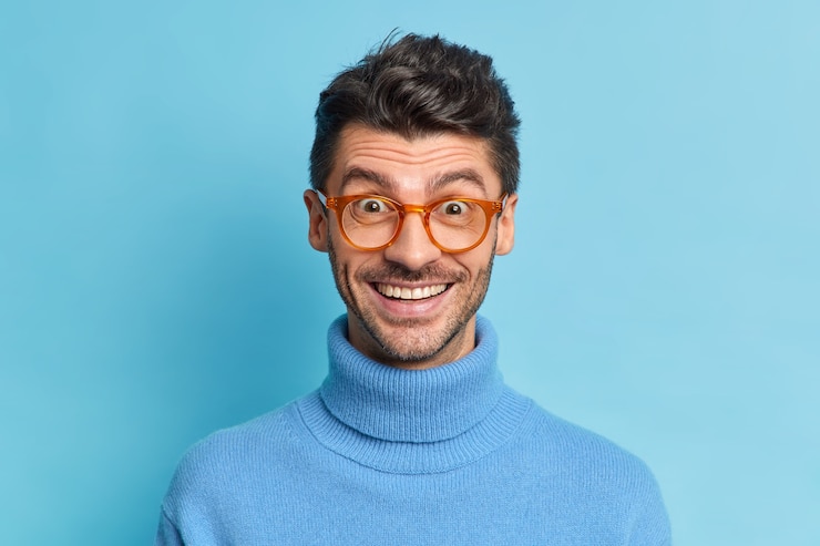 Foto gratuito disparo en la cabeza del chico alegre hipster con sonrisas de cerdas reacciona ampliamente en positivo