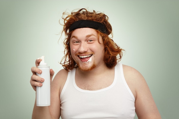 Disparo en la cabeza de feliz excitado joven macho europeo obeso con pelo rizado de jengibre consumiendo calorías extra