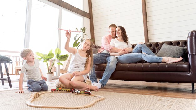 Disparo completo de la familia en la sala de estar