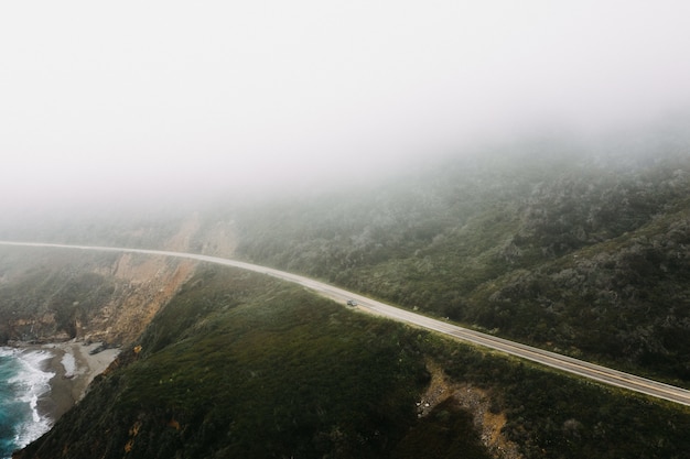 Disparo distante de una carretera cerca de montañas rodeadas de árboles