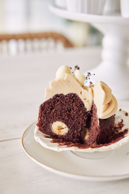 Foto gratuita disparo de enfoque selectivo de delicioso cupcake de chocolate con cobertura de crema blanca