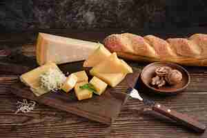 Foto gratuita disparo de enfoque selectivo de un delicioso plato de queso sobre la mesa con nueces y pan