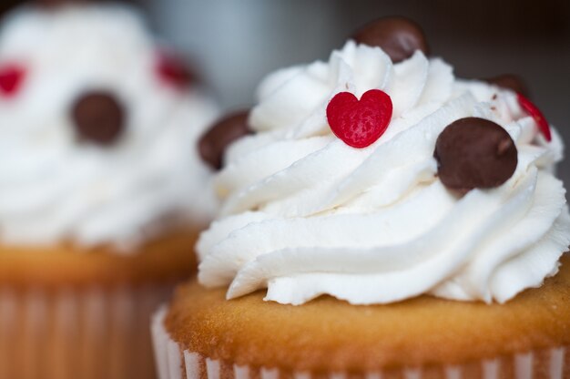 Disparo de enfoque selectivo de glaseado blanco en un cupcake con chispas de chocolate