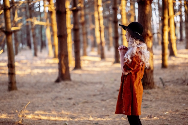 Foto gratuita disparo de enfoque selectivo de una hermosa joven rezando en un bosque