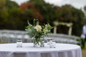 Foto gratuita disparo de enfoque selectivo de hermosas flores en un jarrón sobre una mesa en una ceremonia de boda