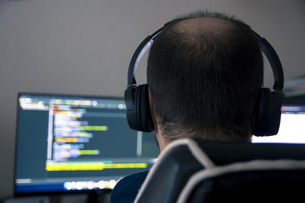 Disparo de enfoque selectivo de un hombre que trabaja en la computadora desde el concepto de hogar de la nueva normalidad
