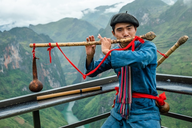 Disparo de enfoque superficial de un hombre vistiendo ropas tradicionales mientras toca un instrumento