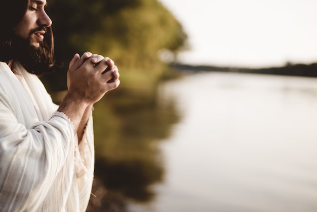 Disparo de enfoque superficial de Jesucristo rezando mientras sus ojos están cerrados