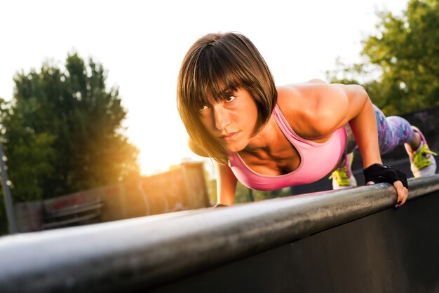 Disparo de enfoque superficial de una mujer deportiva haciendo un entrenamiento en el parque