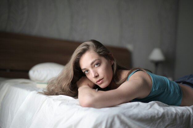Foto gratuita disparo de enfoque superficial de una mujer tendida en la cama