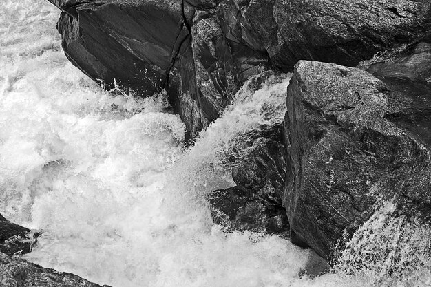 Disparo en escala de grises de formaciones rocosas en el río