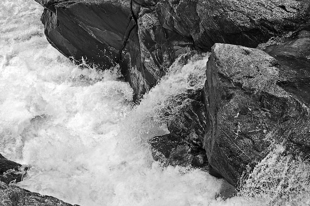 Disparo en escala de grises de formaciones rocosas en el río