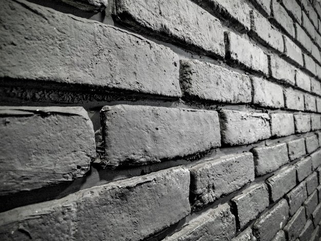 Disparo en escala de grises de una hermosa pared de ladrillo, perfecto para un fondo fresco