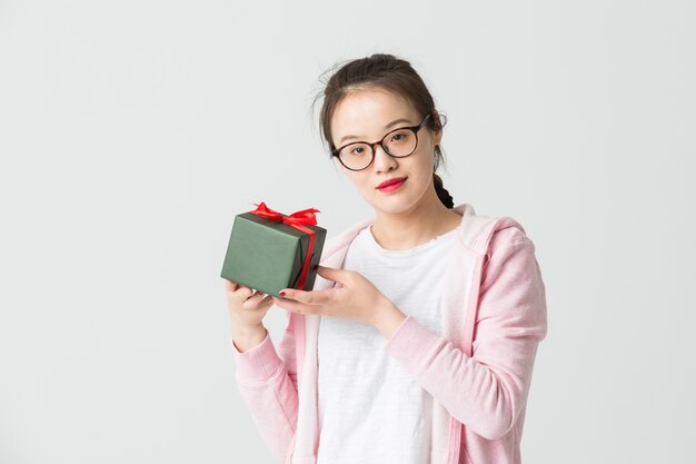 Disparo en el estudio de la joven asiática con un regalo de Navidad