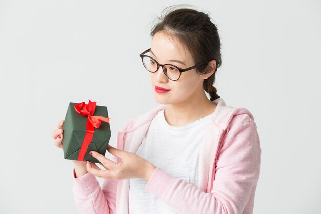 Disparo en el estudio de la joven asiática con un regalo de Navidad