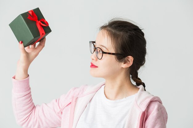 Disparo en el estudio de la joven asiática con un regalo de Navidad