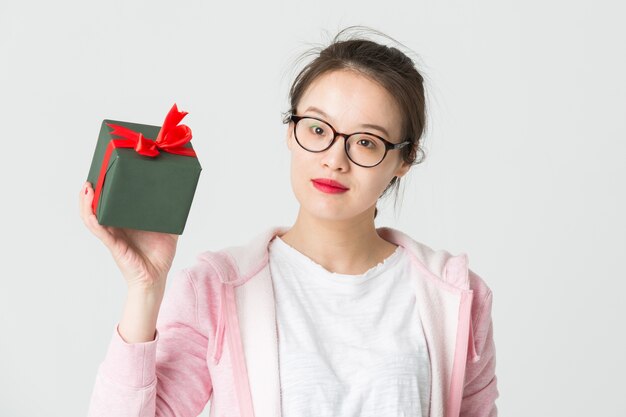 Disparo en el estudio de la joven asiática con un regalo de Navidad