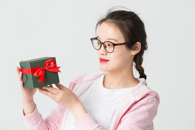 Disparo en el estudio de la joven asiática con un regalo de Navidad