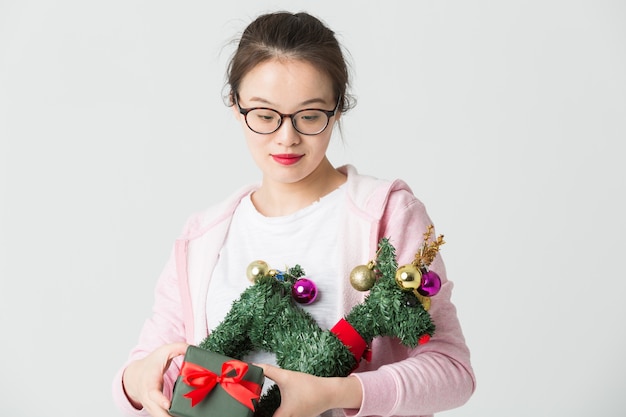 Disparo en el estudio de la joven asiática con un regalo de Navidad