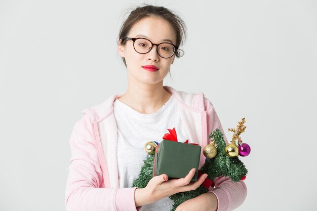 Disparo en el estudio de la joven asiática con un regalo de Navidad