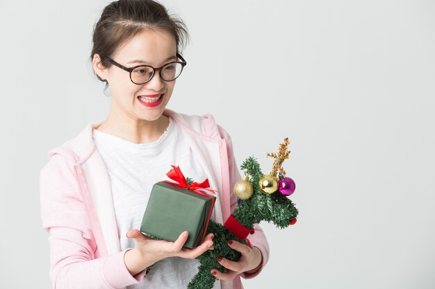 Disparo en el estudio de la joven asiática con un regalo de Navidad