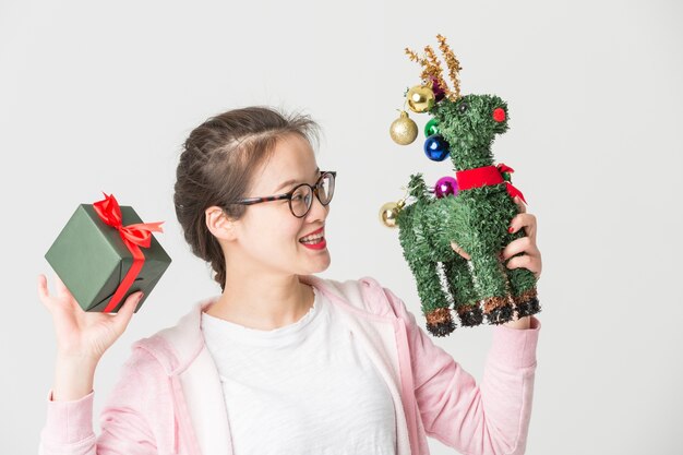 Disparo en el estudio de la joven asiática con un regalo de Navidad