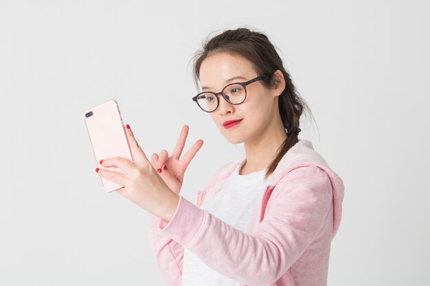 Disparo en el estudio de las mujeres asiáticas jóvenes en el uso de la compañía de telefonía móvil