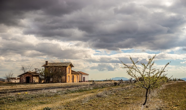 Disparo de gran angular de casas antiguas en un campo verde bajo un cielo nublado