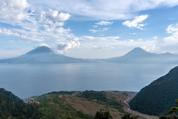 Disparo de gran angular de las montañas frente al mar bajo un cielo azul claro en Guatemala