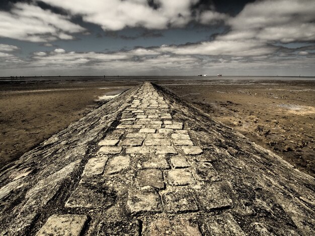 Disparo de gran angular de una pasarela de piedra rodeada por el desierto